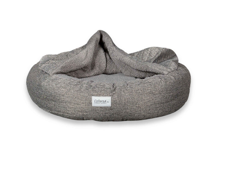 Grey Collared Creatures Cocoon Dog Bed against white background, hood open